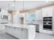 Modern kitchen featuring a spacious island, stainless steel appliances, and white cabinetry at 7661 Moonbeam Ave, Sarasota, FL 34241