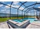 Screened-in pool and spa with brick surround and well-maintained backyard at 7661 Moonbeam Ave, Sarasota, FL 34241