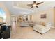 Open living room with L-shaped sofa and view into kitchen at 11734 Hidden Forest Loop, Parrish, FL 34219