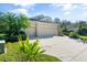 Tan house with three-car garage and neatly landscaped yard at 11734 Hidden Forest Loop, Parrish, FL 34219