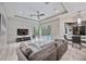 Bright living room featuring stone wall, large TV, and sliding doors to pool at 7521 Trillium Blvd, Sarasota, FL 34241