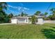 One-story home with gray exterior, a two-car garage, and a landscaped yard at 3523 Whitman St, North Port, FL 34288