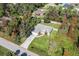 Aerial view of a single-story house with a yard, driveway, and surrounding trees at 3523 Whitman St, North Port, FL 34288