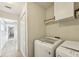 Laundry room with white cabinets, washer and dryer, and extra storage at 12622 Shimmering Oak Cir, Venice, FL 34293