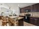 Modern kitchen with granite island, dark cabinetry, and stainless steel appliances at 12622 Shimmering Oak Cir, Venice, FL 34293