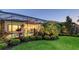 Green backyard with manicured shrubs, lush tropical foliage, screened in patio, and exterior views into the home at 7928 Matera Ct, Lakewood Ranch, FL 34202