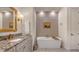 Elegant bathroom featuring a standalone tub, granite countertop, and luxurious fixtures at 7928 Matera Ct, Lakewood Ranch, FL 34202