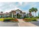 Beautiful clubhouse entrance featuring a red tile roof, lush landscaping, and a brick paver walkway at 7928 Matera Ct, Lakewood Ranch, FL 34202