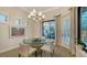 Dining area with glass table, stylish chairs, and view of the outdoor kitchen at 7928 Matera Ct, Lakewood Ranch, FL 34202