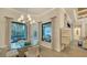 Bright dining area with elegant chandelier, glass table, and views of the outdoor space at 7928 Matera Ct, Lakewood Ranch, FL 34202
