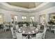 Elegant dining room with tables set for a meal, complemented by ambient lighting and neutral decor at 7928 Matera Ct, Lakewood Ranch, FL 34202