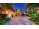 Elegant home exterior featuring a paver driveway, lush landscaping, and a welcoming entrance with decorative accents at 7928 Matera Ct, Lakewood Ranch, FL 34202