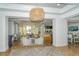 Bright interior view with stylish light fixture, light-colored chairs, and an open floor plan at 7928 Matera Ct, Lakewood Ranch, FL 34202