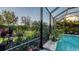 Screened outdoor space with tropical plants and well-maintained landscaping, situated next to a refreshing pool at 7928 Matera Ct, Lakewood Ranch, FL 34202