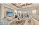Spacious living room with coffered ceiling, large TV, comfortable seating, and decorative accents at 7928 Matera Ct, Lakewood Ranch, FL 34202