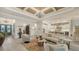Bright living room with coffered ceilings, elegant chandelier, and open floor plan with kitchen view at 7928 Matera Ct, Lakewood Ranch, FL 34202