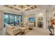 Bright and airy living room with coffered ceiling, TV, access to the outdoor pool area at 7928 Matera Ct, Lakewood Ranch, FL 34202