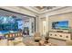 Open living room with view of screened-in pool and patio; featuring large TV and modern decor at 7928 Matera Ct, Lakewood Ranch, FL 34202