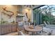 Outdoor kitchen with stainless steel appliances, dining, and open access to the pool deck at 7928 Matera Ct, Lakewood Ranch, FL 34202