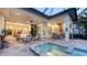 Spacious covered patio with an outdoor dining area, comfortable seating, and views of the sparkling pool at 7928 Matera Ct, Lakewood Ranch, FL 34202