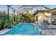 Screened-in pool with attached spa and tranquil tropical garden view from the patio at 7928 Matera Ct, Lakewood Ranch, FL 34202