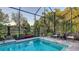 Enjoy the screened pool with surrounding tropical plants and comfortable seating on the tiled patio at 7928 Matera Ct, Lakewood Ranch, FL 34202