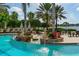A luxurious pool area has tables and chairs with a lake view, fountains, and lounge chairs at 7928 Matera Ct, Lakewood Ranch, FL 34202