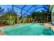 Relaxing screened pool with seating, lush tropical plants and tiled accents offers a private backyard escape at 7928 Matera Ct, Lakewood Ranch, FL 34202