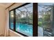 Inviting screened in pool with lush landscaping viewed from a large window at 7928 Matera Ct, Lakewood Ranch, FL 34202