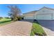 Brick paver driveway leading to a two-car garage at 1269 Backspin Dr, Englewood, FL 34223