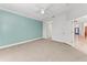 Bedroom with light teal accent wall and carpeting at 1269 Backspin Dr, Englewood, FL 34223