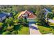 House with tile roof and driveway, surrounded by trees and landscaping at 21 Bayhead Ln, Osprey, FL 34229