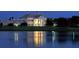 Luxury home exterior at night, reflecting in calm water at 21 Bayhead Ln, Osprey, FL 34229