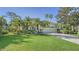Single-story house with landscaped yard, palm trees, and a brick driveway at 21 Bayhead Ln, Osprey, FL 34229