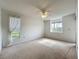 Bright bedroom with neutral carpet, ceiling fan, and windows offering natural light and views of the neighborhood at 4382 Madeira Ct # 3361, Sarasota, FL 34233
