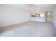 Spacious living room featuring neutral carpet, ceiling fan, and open layout to the kitchen with a breakfast bar at 4382 Madeira Ct # 3361, Sarasota, FL 34233