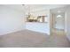 Spacious living room next to kitchen with a hanging light fixture and neutral carpet at 4382 Madeira Ct # 3361, Sarasota, FL 34233