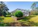 Spacious backyard with a stone retaining wall and lush greenery at 14308 Tugwell Ave, Port Charlotte, FL 33953
