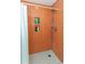 Orange tiled shower with built-in shelves and white hexagon floor at 3740 Lake Bayshore Dr # K501, Bradenton, FL 34205