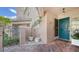 Side entry with teal door, wrought iron gate, and brick walkway at 1713 Starling Dr # 1713, Sarasota, FL 34231