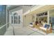 Bright screened porch with two chairs and view into living room at 1713 Starling Dr # 1713, Sarasota, FL 34231