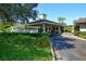 The entrance to the community clubhouse with a covered carport and lush greenery at 1713 Starling Dr # 1713, Sarasota, FL 34231