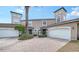 Exterior view of two-story townhome with attached garage and brick driveway at 1713 Starling Dr # 1713, Sarasota, FL 34231