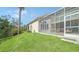 Landscaped backyard with grassy area and screened porch at 1713 Starling Dr # 1713, Sarasota, FL 34231