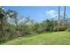 Landscaped backyard with lush greenery and partial water view at 1713 Starling Dr # 1713, Sarasota, FL 34231