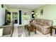 Living room with a leather couch, TV, and access to the outside at 6041 Lilli Way # 72, Bradenton, FL 34207