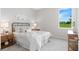 Cozy bedroom with a queen-size bed, nightstands, and a view of the backyard at 27059 Curitiba Dr, Punta Gorda, FL 33983