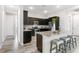 L-shaped kitchen with dark cabinetry, granite island, and stainless steel appliances at 27059 Curitiba Dr, Punta Gorda, FL 33983