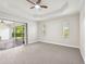 Spacious bedroom with patio access, ceiling fan and carpet flooring at 12221 Perennial Pl, Bradenton, FL 34211