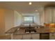 Kitchen with island, granite countertops, and views into the living room at 8191 Varenna Dr, Sarasota, FL 34231